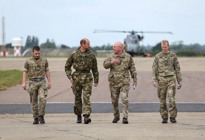 prince william walking with three other men 