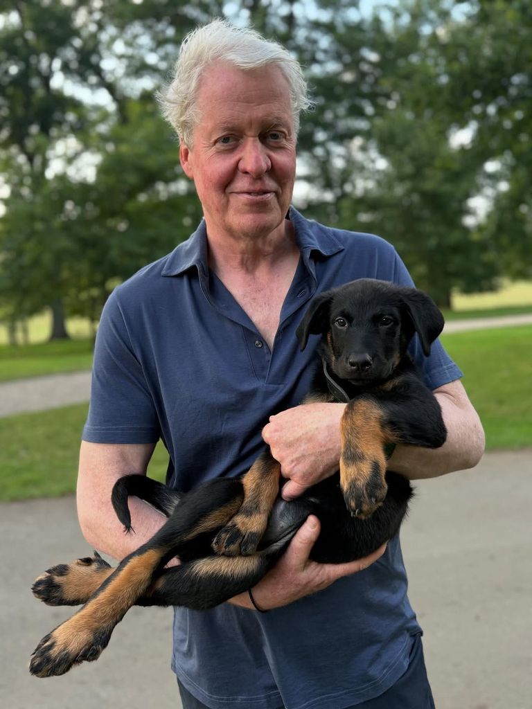 Charles Spencer tenant un chien à Althorp