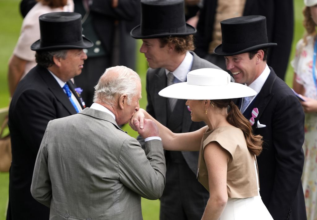 King Charles III kisses the hand of Princess Eugenie