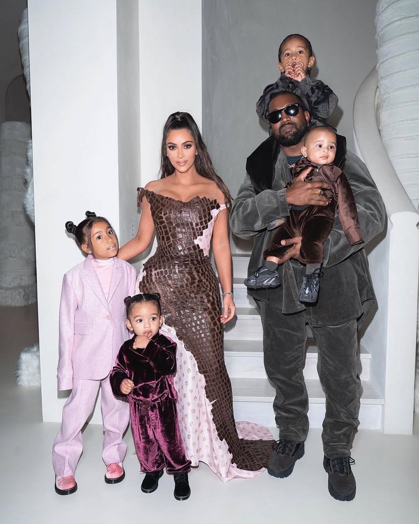 Kim Kardashian and Kanye West posing with their four children