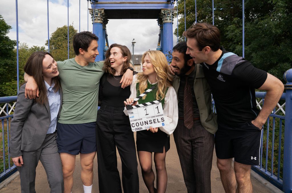 group of young people standing on bridge with clapper board