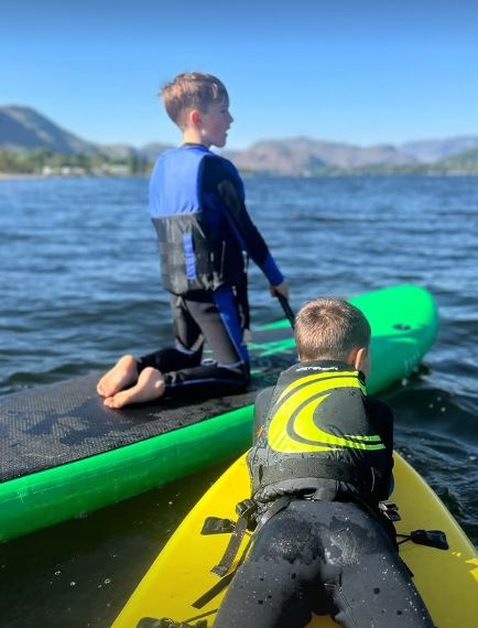 Two young boys on paddleboards