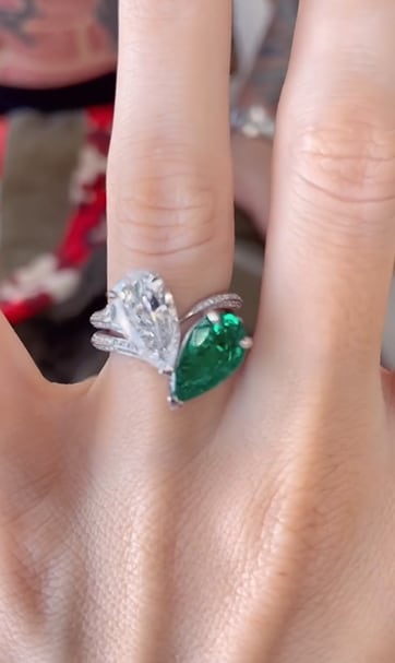 megan fox engagement ring with one diamond, one emerald up close