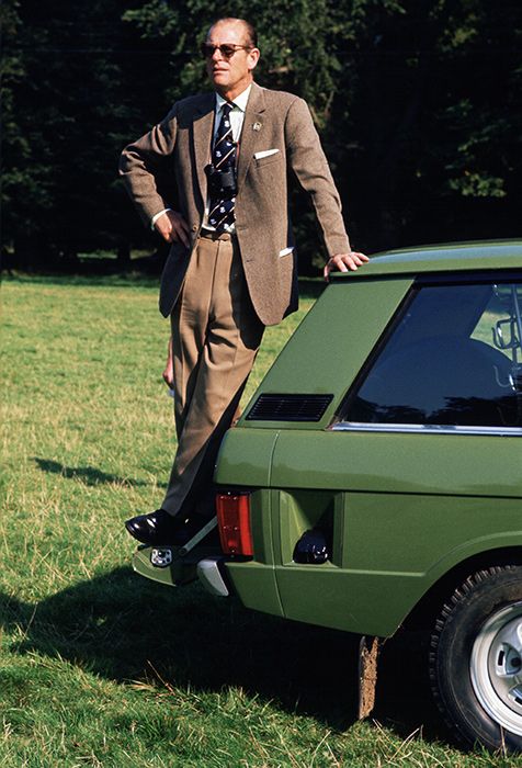 prince philip standing on top of his land rover