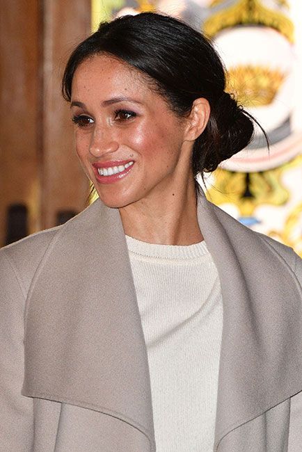 mid shot of meghan wearing beige and smiling as she looks to her right