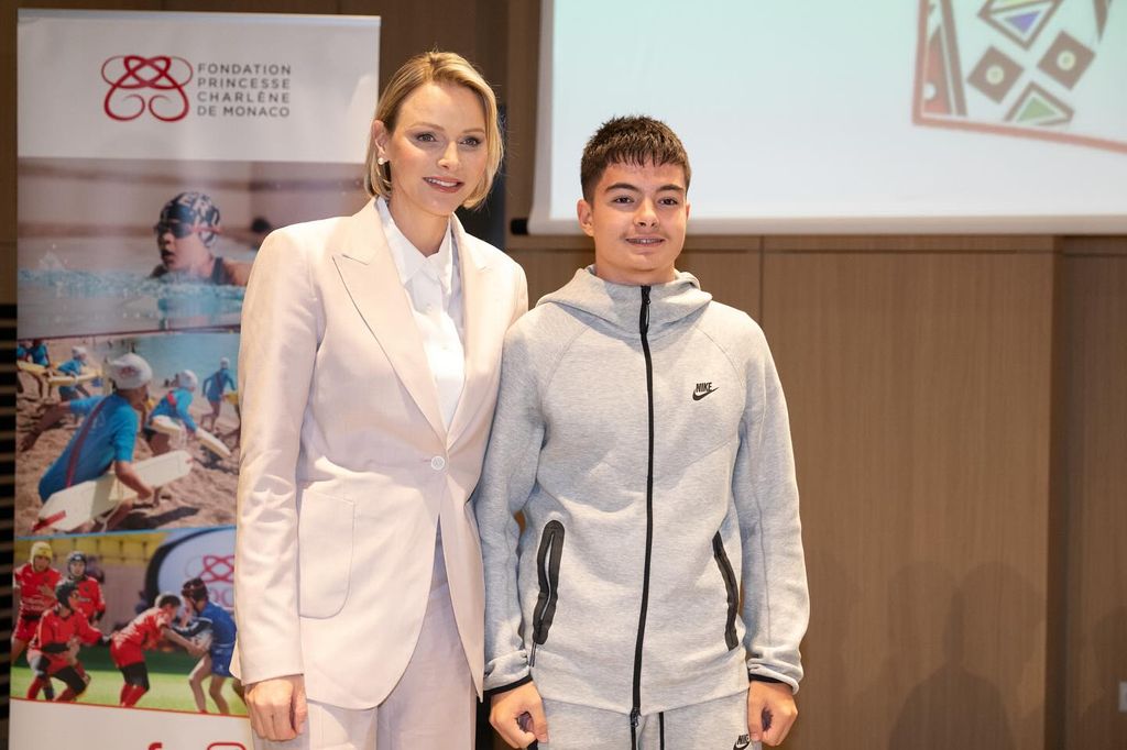 Princess Charlene in a pale pink suit with young boy