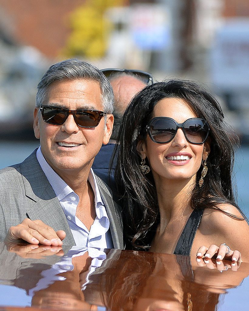 US actor George Clooney ( L) and his Lebanon-born British fiancee Amal Alamuddin take a taxiboat upon their arrival in Venice on September 26, 2014, on the eve of their wedding.    AFP PHOTO / ANDREAS SOLARO        (Photo credit should read ANDREAS SOLARO/AFP via Getty Images)