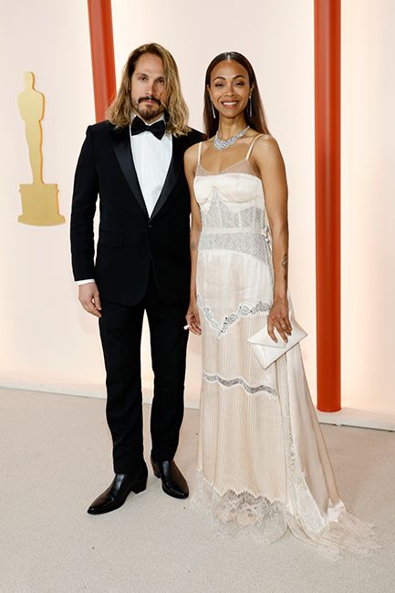 zoe saldana in white dress with silver jewels at oscars with marco perego