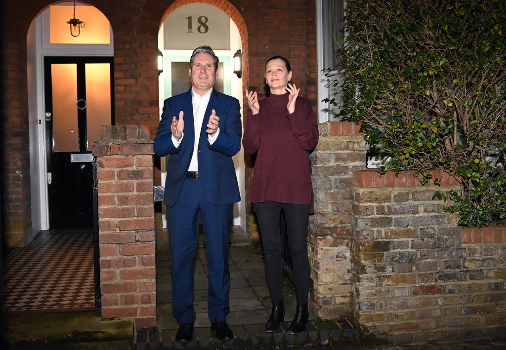 Keir and Victoria Starmer clapping outside their home