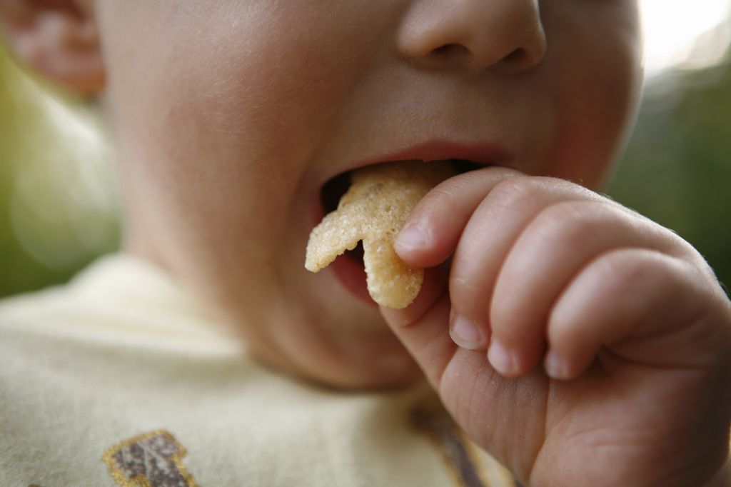 Gros plan d'un bébé garçon mangeant des chips de pommes de terre 