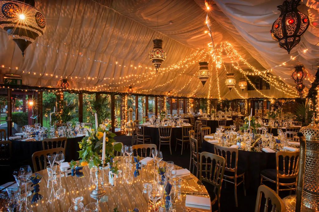 event space decorated with fairylights and table settings 