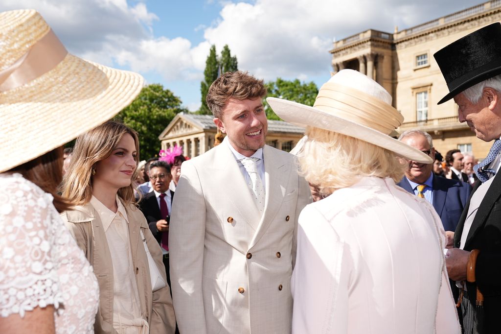 Queen Camilla speaks with Roman Kemp at The Creative Industries Garden Party at Buckingham Palace on May 15, 2024 