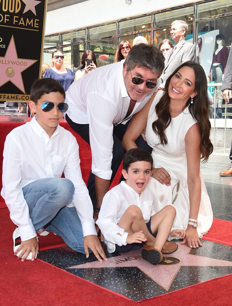 The family all together posing around Simon's Hollywood star