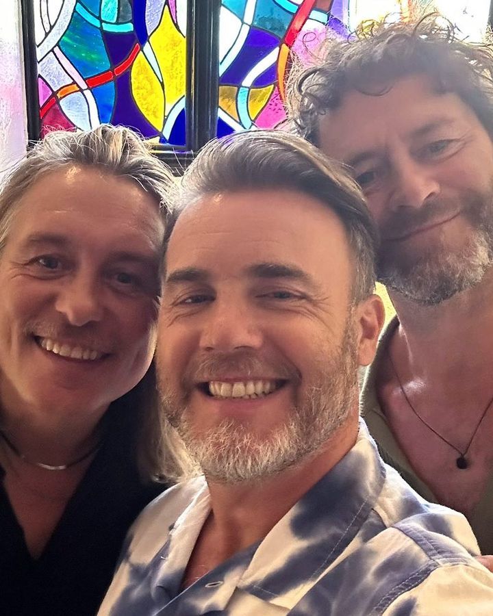 Gary Barlow, Mark Owen and Howard Donald smiling