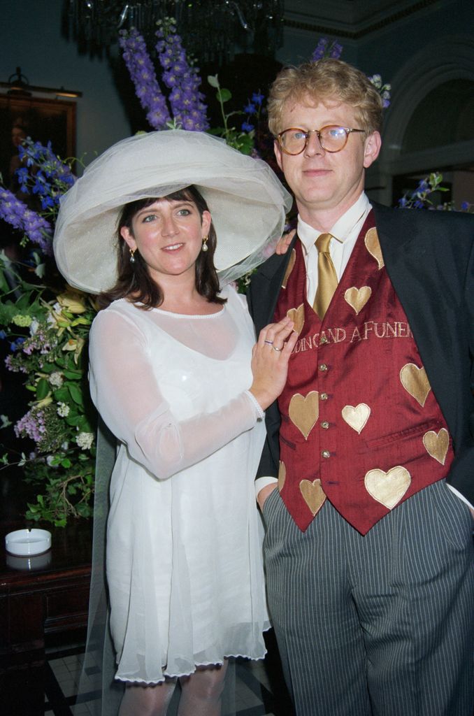 Emma Freud in a white outfit standing with Richard Curtis