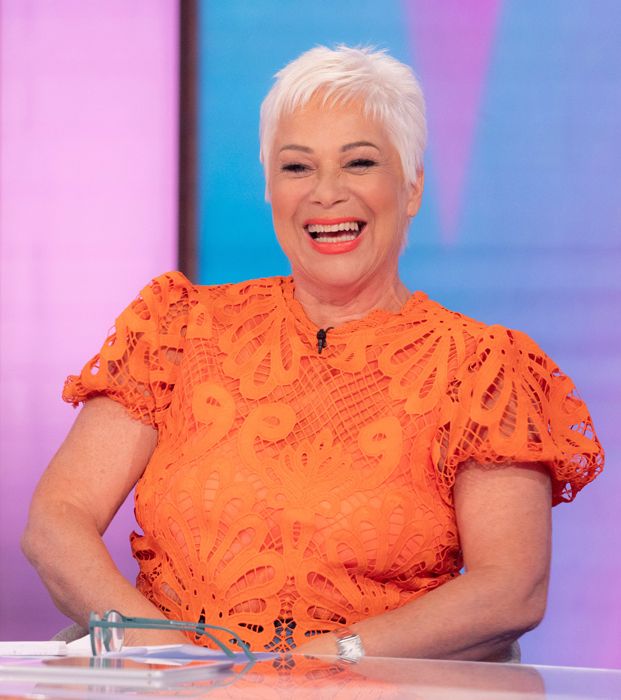 Denise Welch laughing in a bright orange top