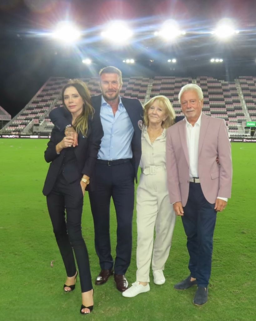 Victoria posed with David and parents Jackie and Tony on football pitch