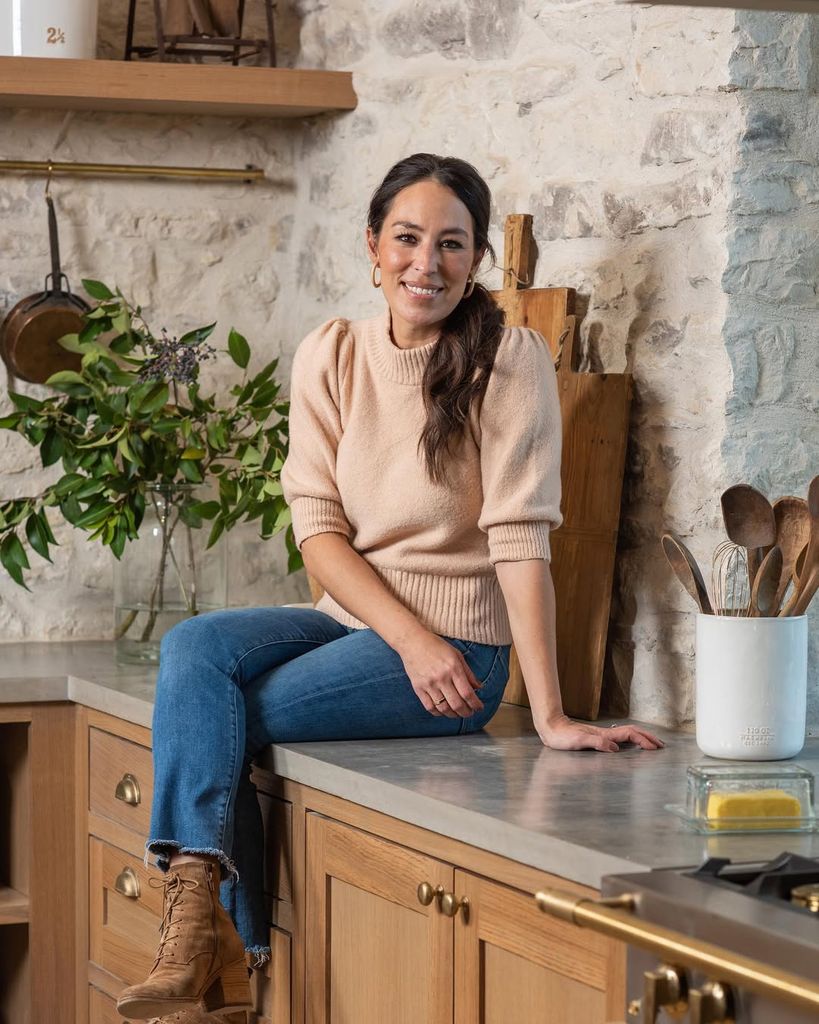 Joanna Gaines sits on a countertop