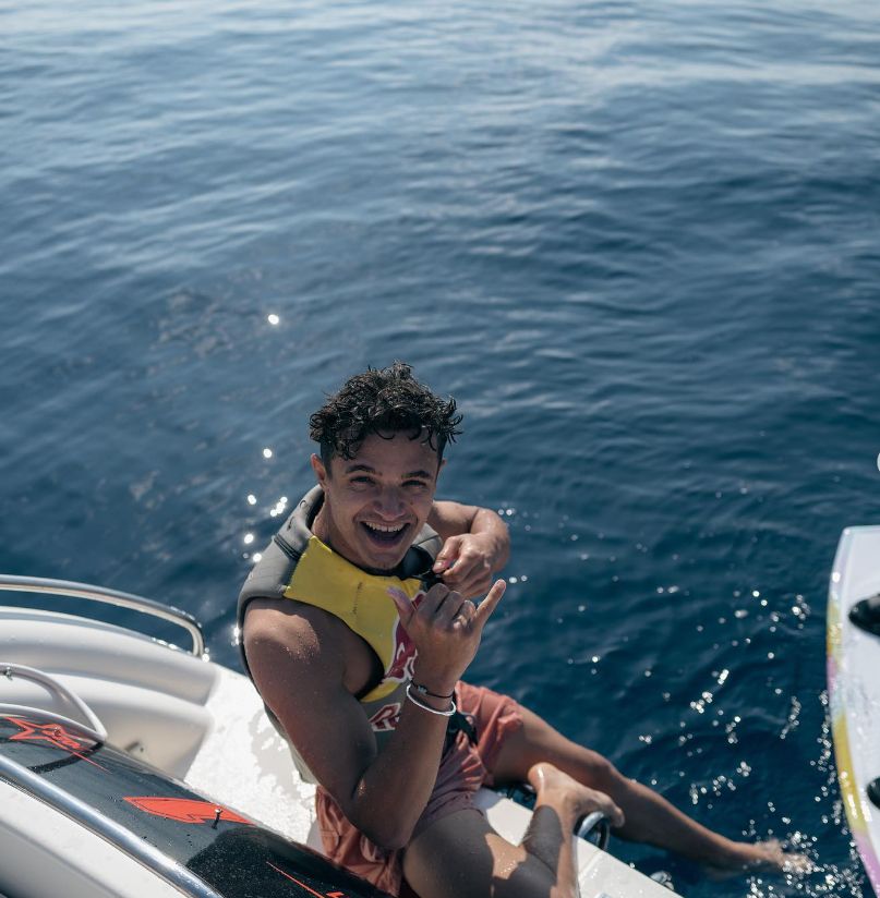 Lando Norris in a life jacket on a yacht
