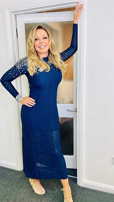 Carol Vorderman posing in her blue dress