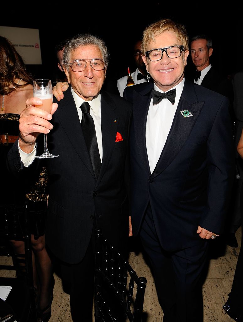 Tony Bennett holding a glass of champagne with Elton John