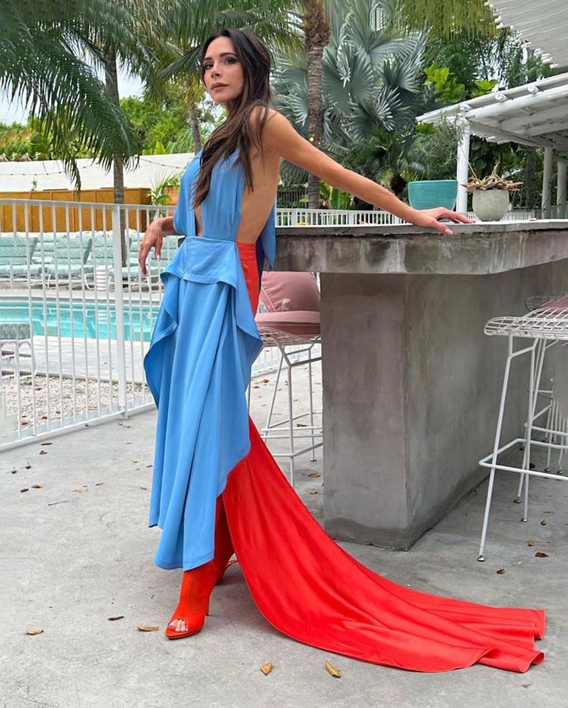victoria beckham in a plunging red and blue dress from her own clothing line