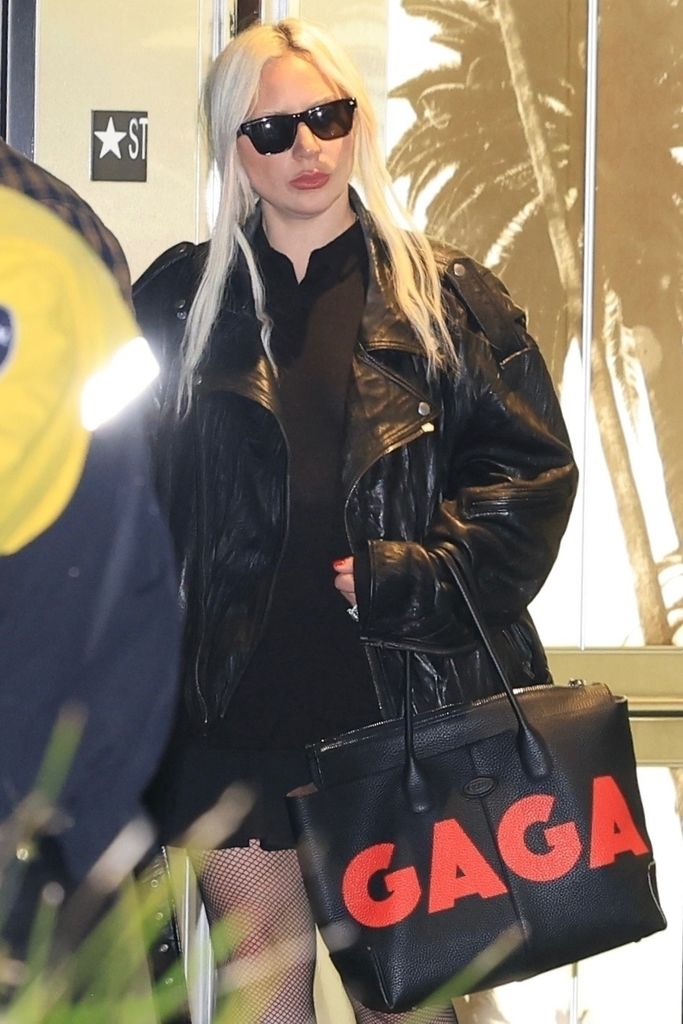 Lady Gaga stepped out in an all black ensemble and continues to wear her huge diamond engagement ring. She made a bold statement by accessorizing her look with a huge purse with her name in bold red. 