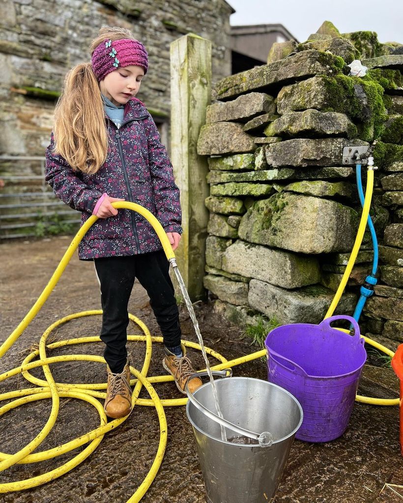 Amanda Owen's daughter fills up bucket in photo from Ravenseat Farm