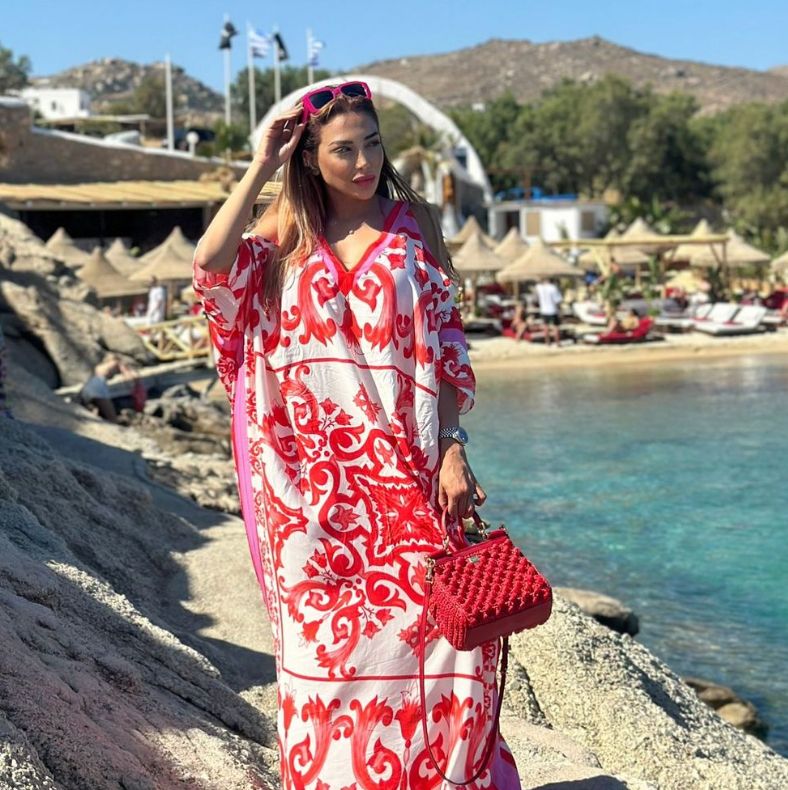 Farah El Kadhi in a red and white kimono on rocks next to the sea