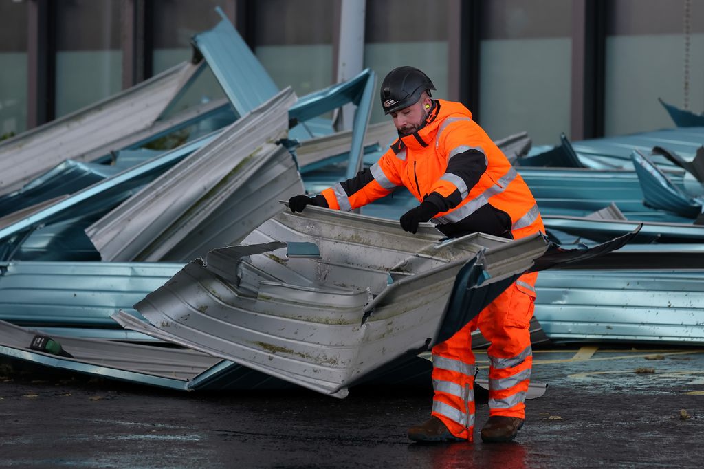 A worker clearing up debris from a leisure centre following a storm