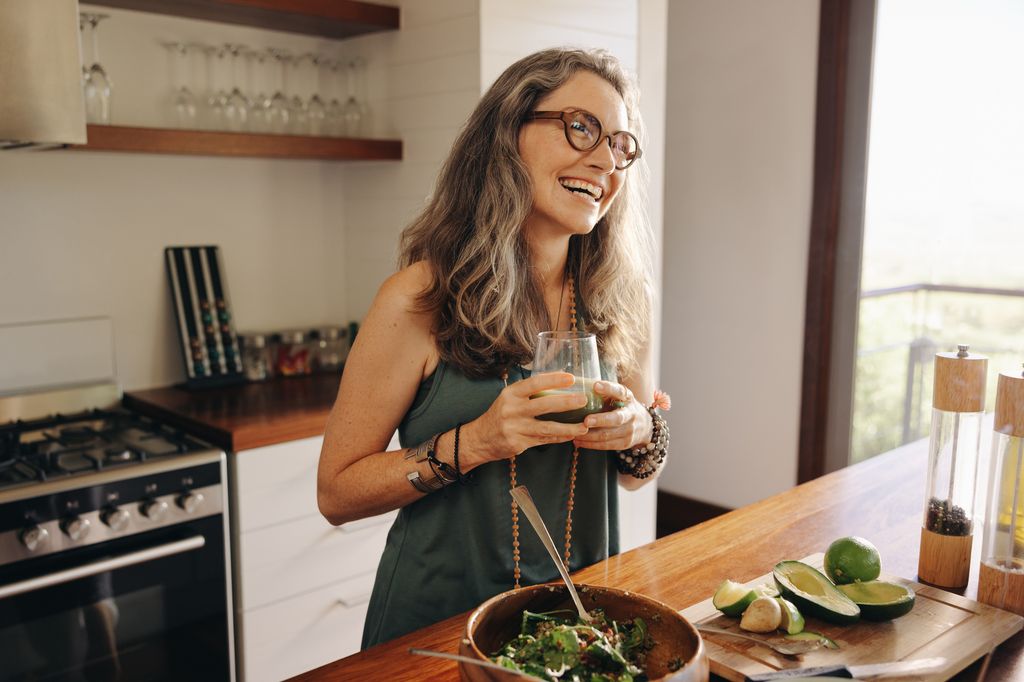 woman eating green salad and drinking green juice.