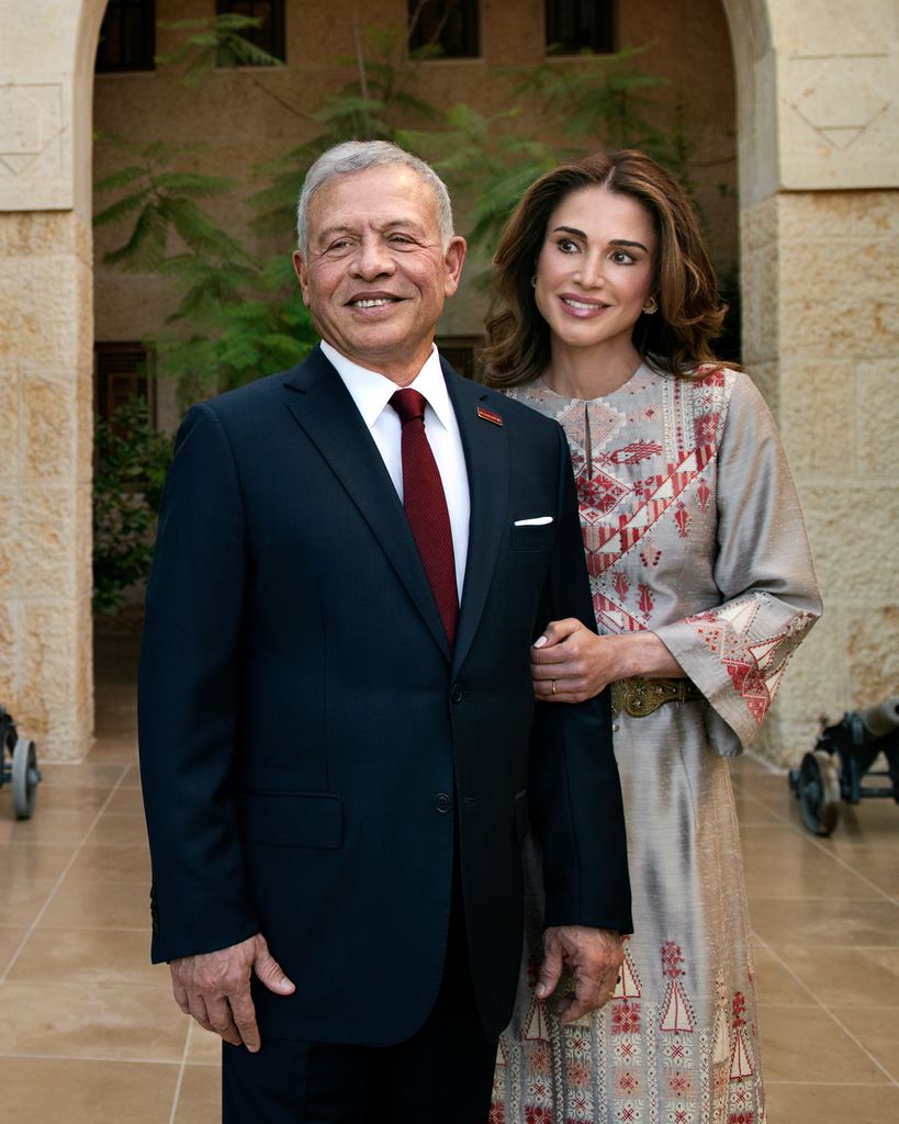 King Abdullah in suit beside queen rania in traditional Arabic dress