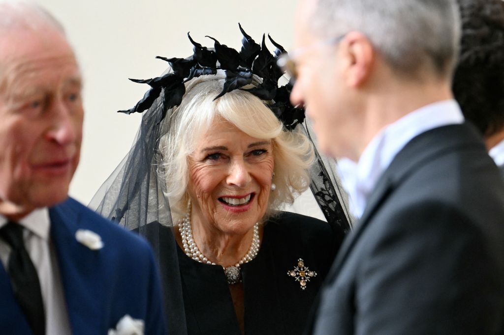 The Queen wore a "raspberry pip" brooch in the shape of cross, which belonged to the late Queen