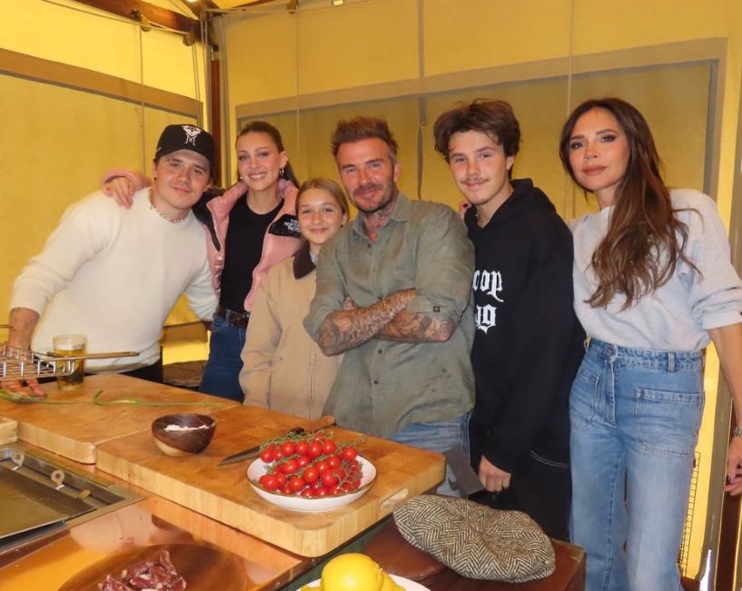 Brooklyn Beckham standing with Nicola Peltz, Harper Beckham, David Beckham, Cruz Beckham and Victoria Beckham in front of food