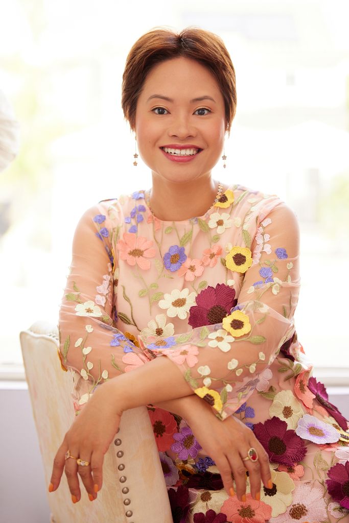 Helen wearing a floral dress and smiling at the camera
