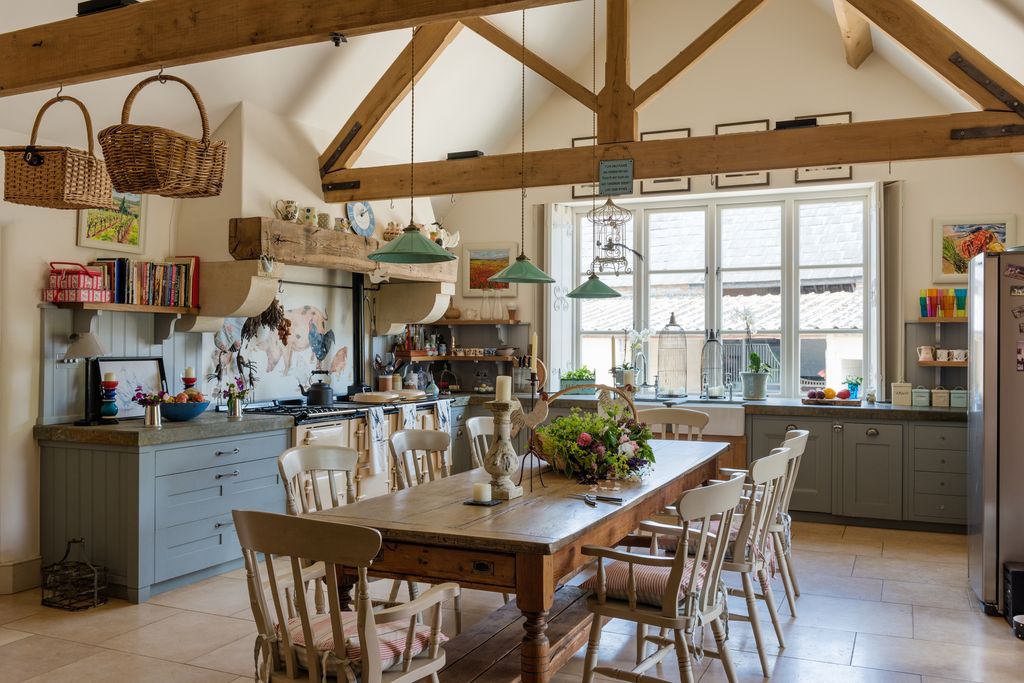 Vintage farmhouse table in rustic kitchen with green pendant lights
