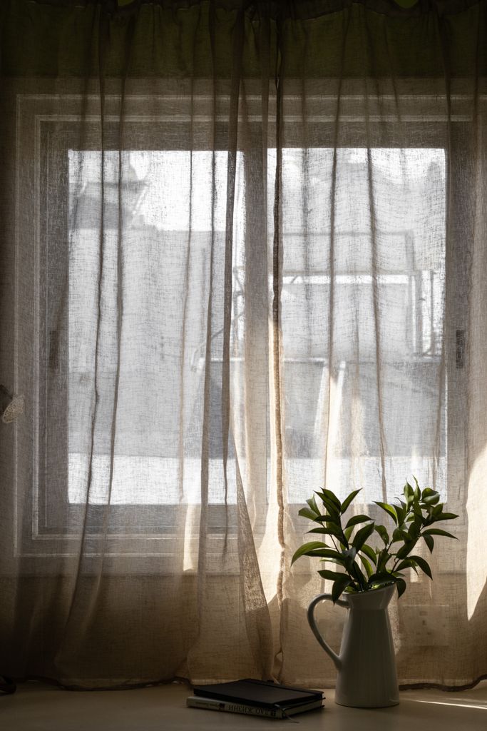 Sheer curtains letting light through a double-pane window