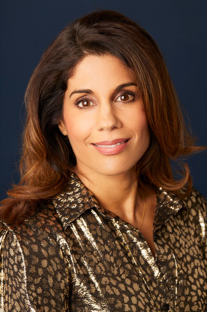 Smiling brunette woman in a black and gold leopard print shirt