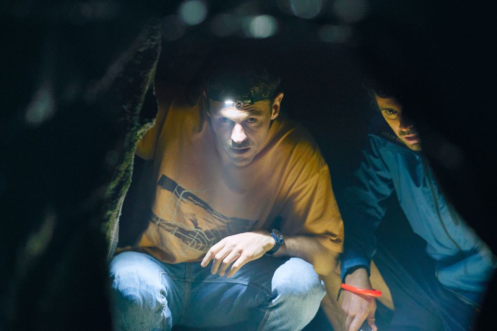 man wearing head-torch in dark tent