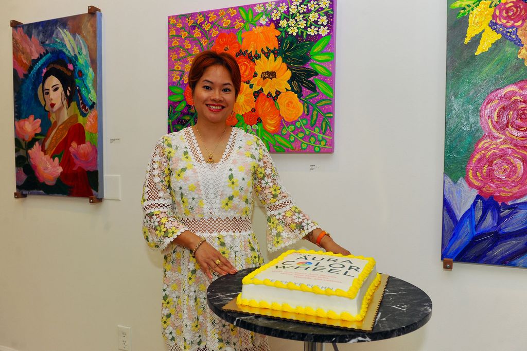 Helen poses with a giant cake made in the image of her book cover