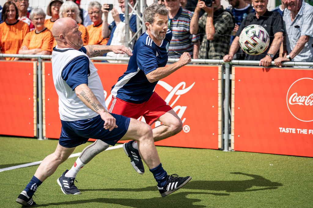 Denmark's Crown Prince Frederik (R) and former Danish midfielder Stig Toefting vie for the ball during a show football match during the opening of the UEFA Euro 2020 fan zone 'Football Village' at Ofelia Plads in Copenhagen, Denmark