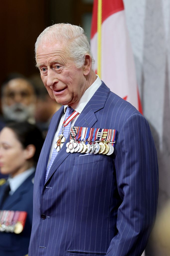 King Charles III smiles as he stands in the Senate Chamber for the State Opening of Parliament during an official visit to Canada