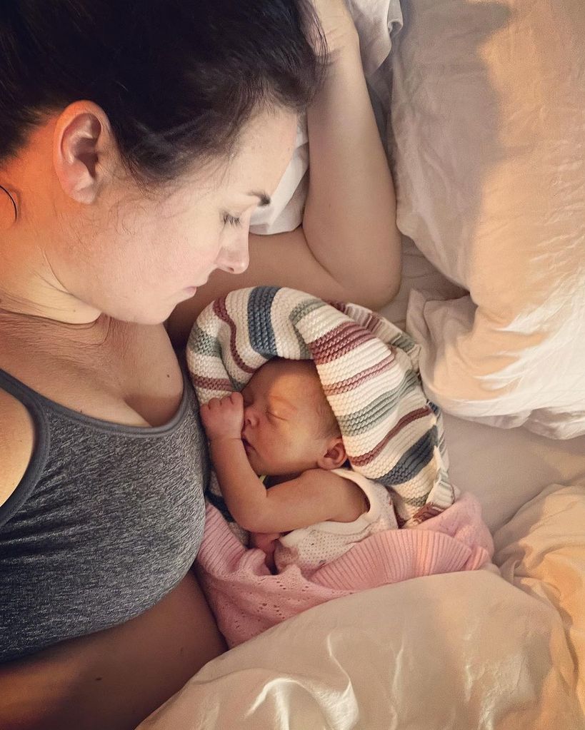 Nina Warhurst laying beside newborn baby girl Nance