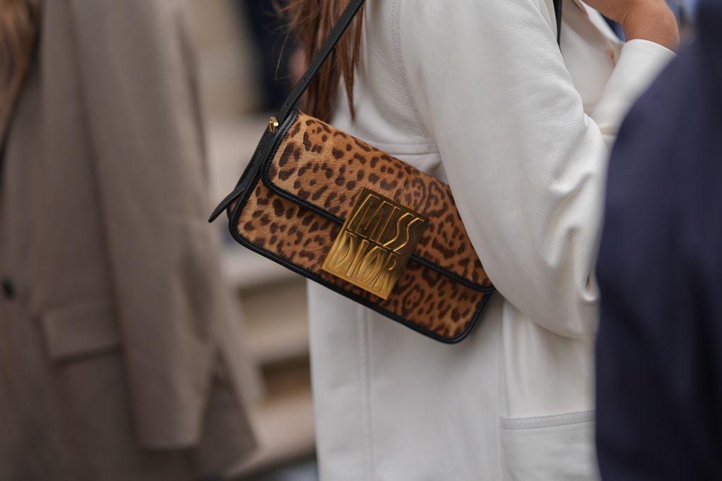 Bolsa de couro Dior Miss Dior com estampa/padrão leopardo, jaqueta blazer branca oversized, fora da Dior, durante a Paris Fashion Week Primavera/Verão 2025 em 24 de setembro de 2024 em Paris, França.