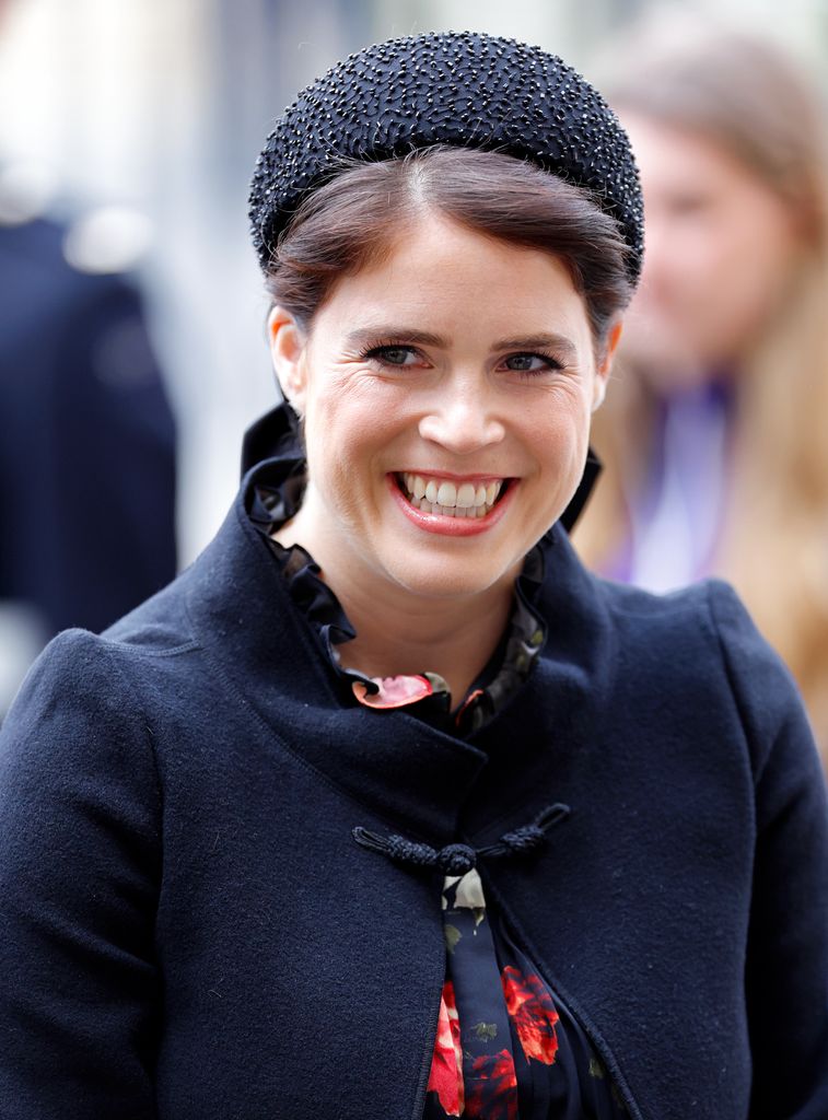 Princess Eugenie grinning wearing black headband