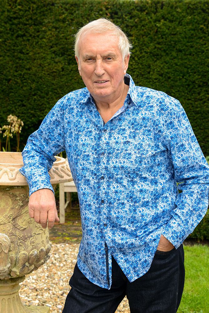 Johnnie Walker wearing a blue shirt in his garden