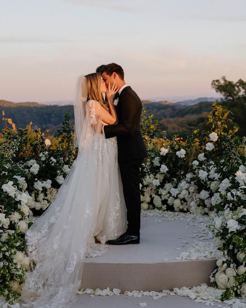 Taylor Lautner kissing his bride on their wedding day