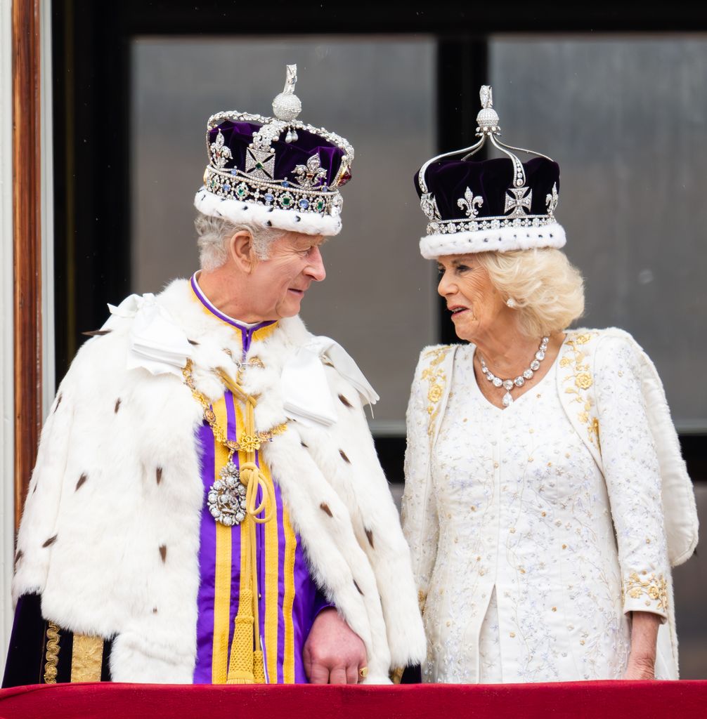 King Charles in his coronation robes talking to Queen Camilla