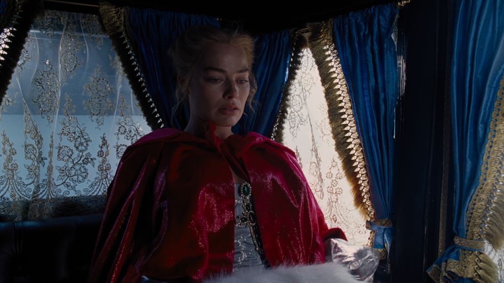 Margot Robbie dans la cape rouge pendant "Les Hauts de Hurlevent" tournage