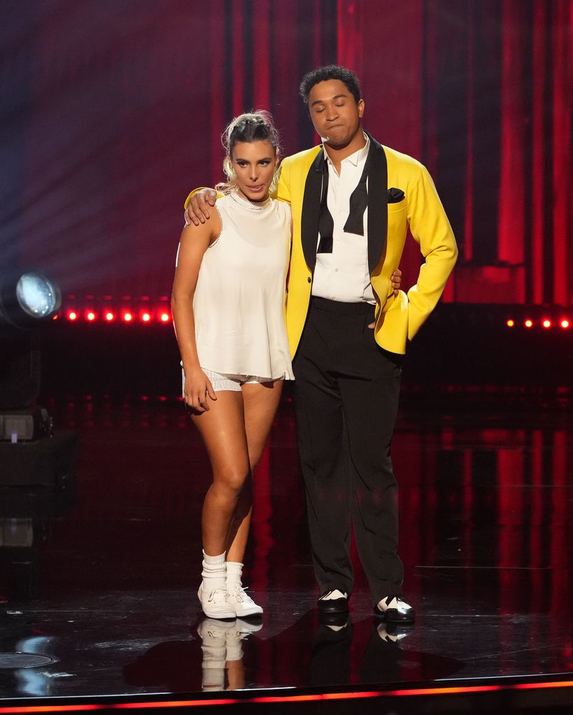Lele Pons and Brandon Armstrong stand on the dancefloor awaiting results on DWTS